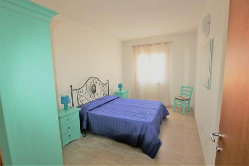 1 dormitorio con 1 cama azul y 1 silla en SHR Badesi, en Badesi