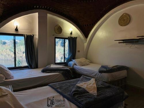 a room with three beds and a window at Torya Nubian House in Aswan