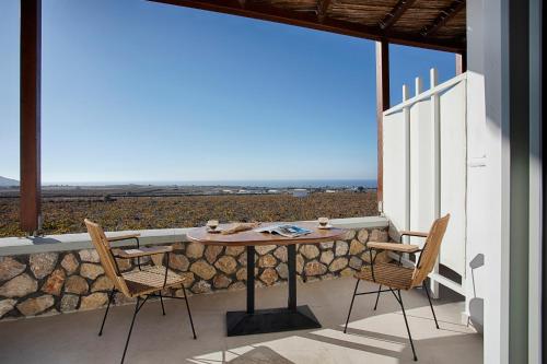 a table and chairs on a balcony with a view at New Villa Katerina Collection in Megalokhori