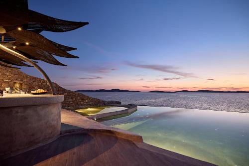 a swimming pool with a view of the water at Amazon Mykonos Suites & Spa in Agios Ioannis Mykonos