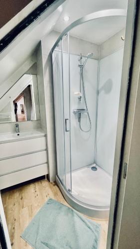 une salle de bain avec une douche avec une porte vitrée dans l'établissement Le penty de Lesquiffinec, à Crozon
