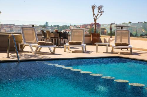 a swimming pool with chairs and a table on a roof at Valley Boutique Hotel in Safi