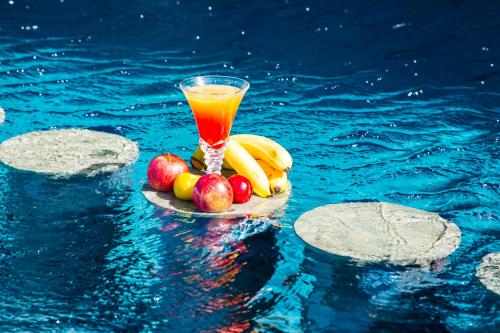 a glass of juice and fruit on a plate in the water at Valley Boutique Hotel in Safi