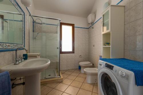 a bathroom with a washing machine and a sink at La Casa delle Zie - Cabras in Càbras