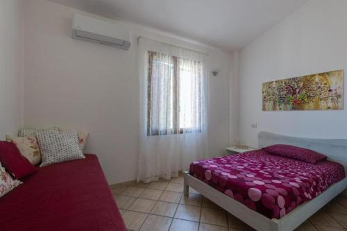 een slaapkamer met een bed, een bank en een raam bij La Casa delle Zie - Cabras in Càbras