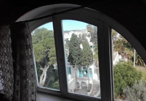 a window with a view of a house at la casbah in Hammamet