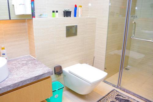 a bathroom with a toilet and a glass shower at GTC 1Br Apartment on Westlands Road -with Gym& Pool in Nairobi