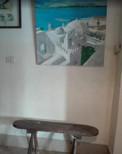 a bench in a room with a picture on the wall at la casbah in Hammamet