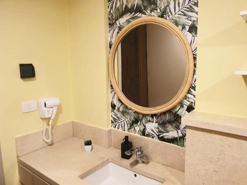 ein Badezimmer mit Waschbecken und Spiegel in der Unterkunft Mangroovy - 1BR GF +2 wall beds Garden & Pool view in Hurghada