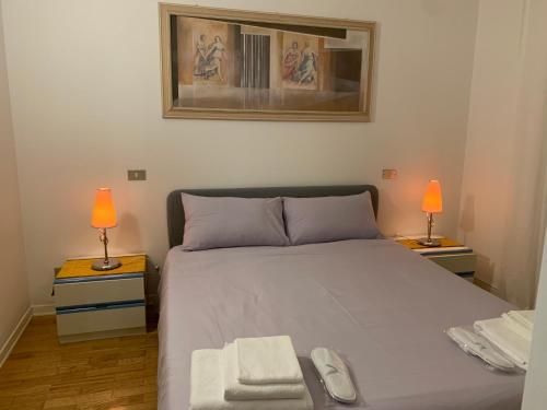 ein Schlafzimmer mit einem Bett mit zwei Lampen und zwei Handtüchern in der Unterkunft Residence Villa Valmarana De Toni in Creazzo