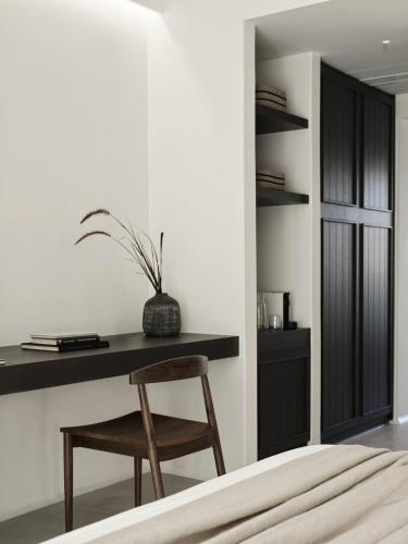 a bedroom with a desk and a wooden chair at Ezio Bo Luxury Living in Mýkonos City