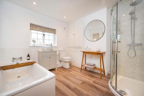 a bathroom with a tub and a sink and a shower at 3 Lower Falkland Cottage Long Melford in Sudbury