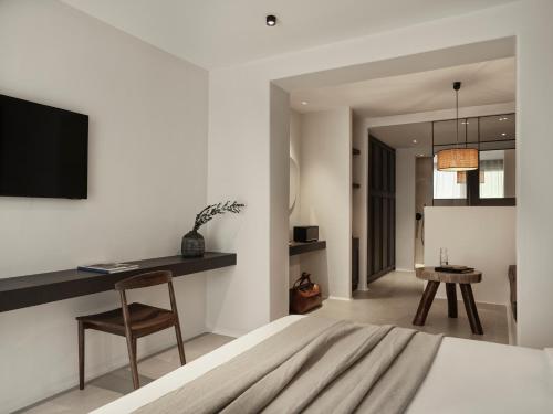 a bedroom with a bed and a desk and a chair at Ezio Bo Luxury Living in Mýkonos City