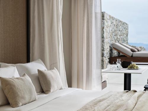 a bedroom with a bed and a table and a window at Ezio Bo Luxury Living in Mýkonos City