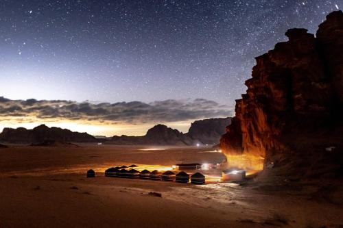 un camión conduciendo por el desierto por la noche en Desert Bird Camp, en Wadi Rum