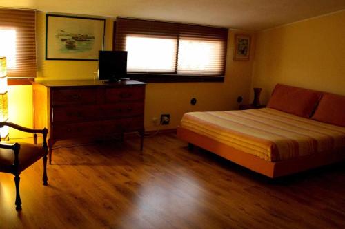 a bedroom with a bed and a dresser and a window at Domus Sol Aria in Castiadas