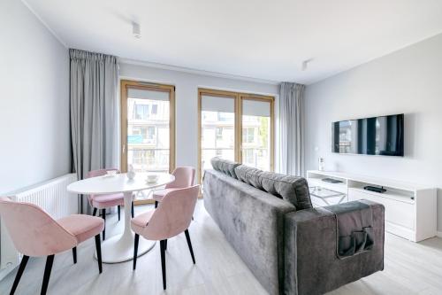 - un salon avec un canapé, une table et des chaises dans l'établissement DR Apartments - Mavik, à Sopot