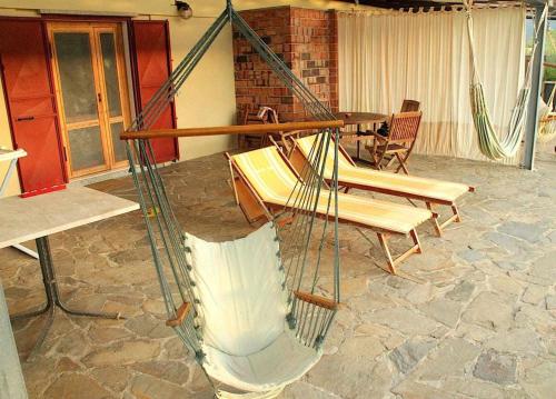 a hammock in a patio with a table and chairs at Domus Sol Aria 2 in Castiadas