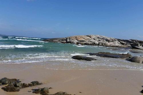 a beach with some rocks in the water at Domus Sol Aria 2 in Castiadas