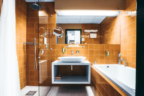 a bathroom with a sink and a bath tub at Arensburg Boutique Hotel & Spa in Kuressaare