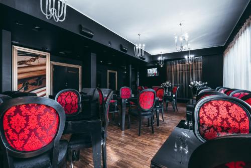 a dining room with red chairs and a table at Arensburg Boutique Hotel & Spa in Kuressaare