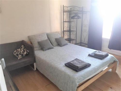 une chambre avec un lit et un canapé dans une pièce dans l'établissement Appartement entier proche de Paris., à Clichy