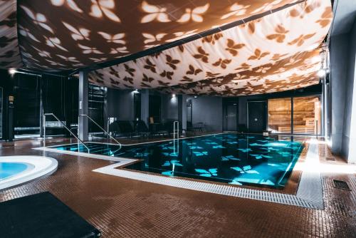 a large swimming pool in a room with a ceiling at Arensburg Boutique Hotel & Spa in Kuressaare