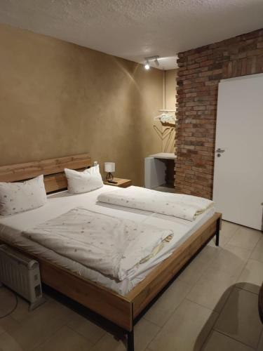 a large bed in a room with a brick wall at Lindenhof Liepgarten - Pension & Gaststätte in Ueckermünde
