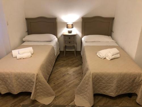 a room with two beds with towels on them at City Garden Guest House in Olbia