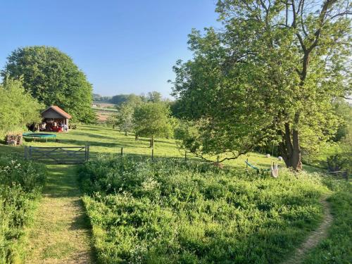 a path through a field with a barn in the background at Nachtegael Zomerhuis, idyllische woning in de Vlaamse Ardennen in Kluisbergen