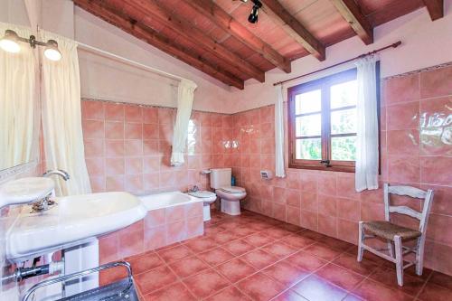 ein Bad mit einem Waschbecken, einem WC und einem Fenster in der Unterkunft Can Font Roig in Pollença