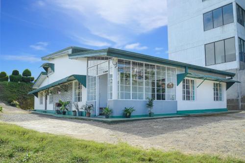 un edificio blanco con plantas delante en Gregory House Hostel en Nuwara Eliya