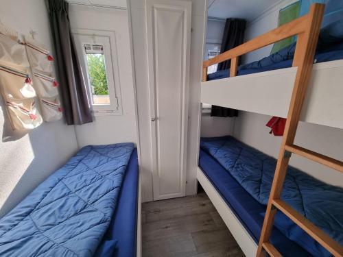 2 Etagenbetten in einem kleinen Zimmer mit einer Leiter in der Unterkunft Chalet Texel DREaM nr. 17 op Chaletpark Bregkoog in De Koog