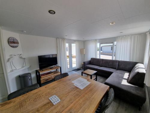 een woonkamer met een bank en een tafel bij Chalet Texel DREaM nr. 17 op Chaletpark Bregkoog in De Koog