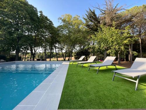 - une rangée de chaises longues assises sur l'herbe au bord de la piscine dans l'établissement Can Jan Vives, à Vidreres