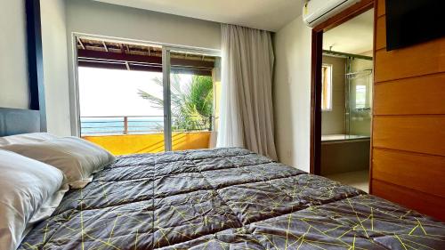 1 dormitorio con cama y ventana grande en Ap climatizado com vista mar no Rio Vermelho, en Salvador