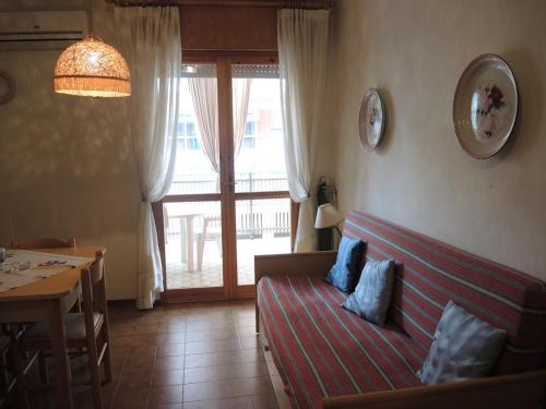 - un salon avec un canapé en face d'une fenêtre dans l'établissement Warm two-room flat with terrace near the beach, à Bibione