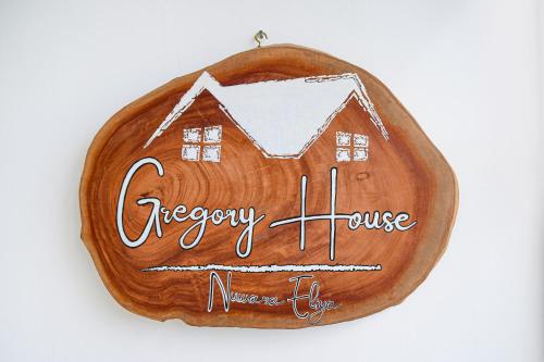 a wooden sign with a house on it at Gregory House Hostel in Nuwara Eliya