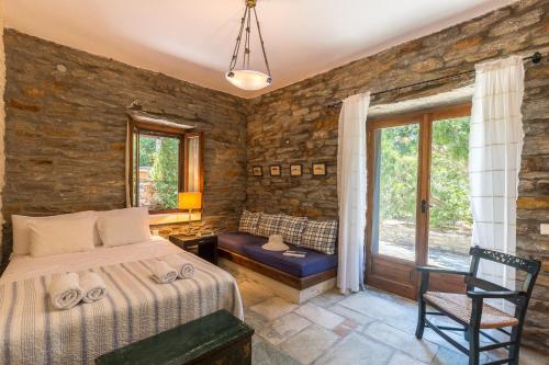1 dormitorio con 1 cama, 1 silla y 1 ventana en Villa Myrto, breathtaking Aegean view, 5' from Koundouros beach, en Koundouros