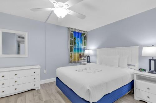 a white bedroom with a bed and a ceiling fan at Stunning Oceanfront Views w Pool - Atlantica Towers Condo in Myrtle Beach