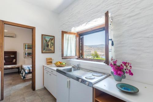 cocina con fregadero y ventana en Villa Myrto, breathtaking Aegean view, 5' from Koundouros beach, en Koundouros