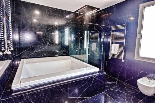 佩亚Coral Bay Beach Villa的带浴缸和水槽的蓝色浴室