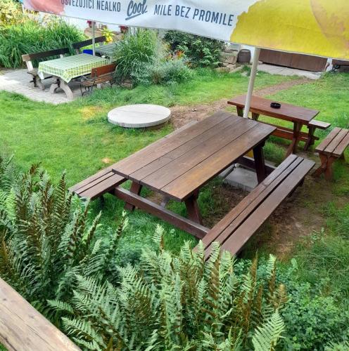 a wooden picnic table and bench in a park at Soukromá rezidence Pohádková usedlost Lovětín in Lovětín