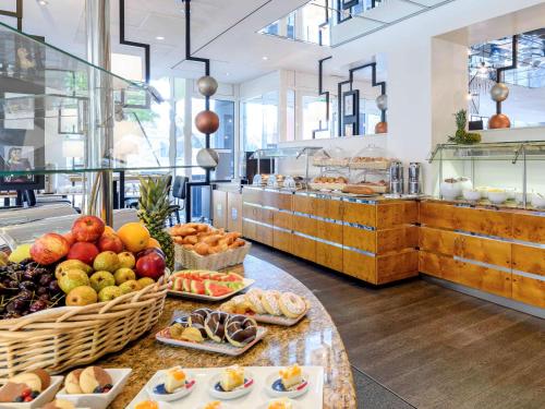 a bakery with a display of fruits and pastries at Mercure Hotel Bochum City in Bochum