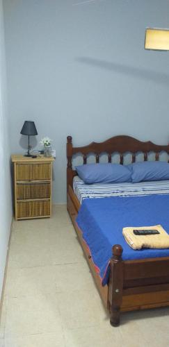 - une chambre avec un lit en bois et une table de chevet dans l'établissement COMPLEJO Aires del Ñapindá, à Paraná