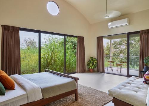 ロナバラにあるSaffronStays Yahvi Waters by Kosha Villas, Pawna - pool villa with stunning lake viewのベッドルーム1室(ベッド1台、大きな窓付)
