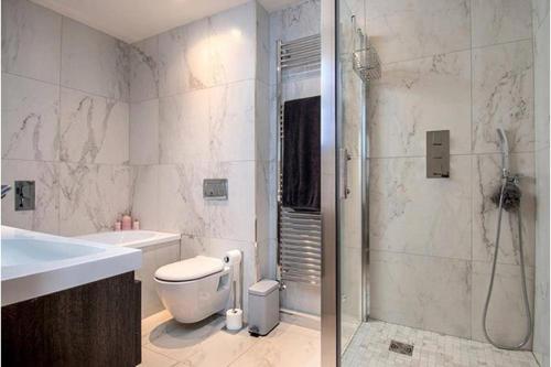 ein Badezimmer mit Dusche, Toilette und Waschbecken in der Unterkunft Deganwy Tower Apartment in Deganwy