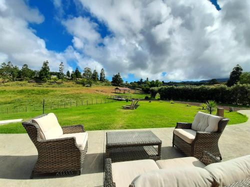 eine Terrasse mit einem Sofa, Stühlen und einem Feld in der Unterkunft Quinta de São José in São Pedro