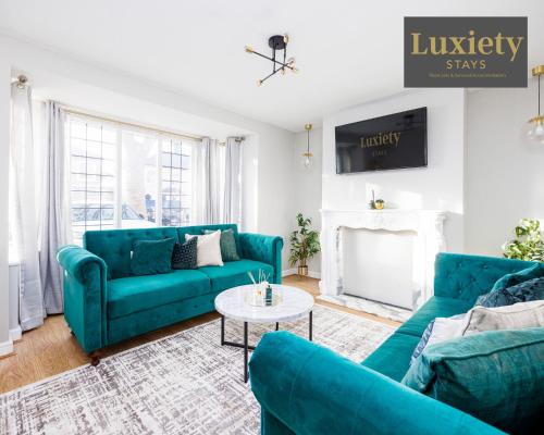 a living room with blue couches and a table at Modern house - City Centre - Contractors Hub, Families, Free Parking by Luxiety Stays in Southend-on-Sea