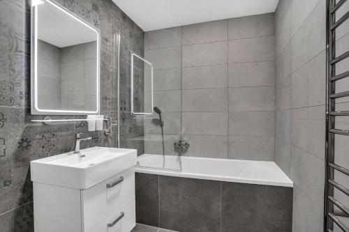 La salle de bains blanche est pourvue d'un lavabo et d'un miroir. dans l'établissement Apartmány Vista Klínovec, à Loučná pod Klínovcem